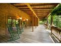 Long wooden porch with rocking chairs, offering a view of the woods at 6255 Meadow Ln, Salisbury, NC 28147