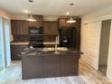 Kitchen with dark cabinets, granite counters, and island at 5756 Dalmatian St, Iron Station, NC 28080