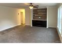 Living room with wood-look wall and carpet flooring at 5716 Dalmatian St, Iron Station, NC 28080