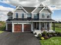Two-story farmhouse with gray siding, brown accents, and a three-car garage at 11330 James Coy Rd # Covington, Davidson, NC 28036