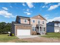 Two-story house with stone and vinyl siding, a white garage door and landscaping at 1030 Heath Helms Rd, Monroe, NC 28110