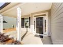 Inviting front porch with columns and a black front door at 8631 Frank Grier Rd # 6, Charlotte, NC 28215