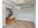 Simple dining room with hardwood floors and chandelier, open to living area at 224 Winford Dr, Troutman, NC 28116
