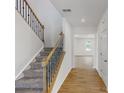 Stairwell with wood railing and carpet runner, leading to an open living area at 224 Winford Dr, Troutman, NC 28116