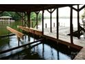 Covered boat lift with wooden dock and lake views at 165 Clearview Point Dr, Mount Gilead, NC 27306