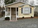 Attractive tan manufactured home with a covered porch at 104 Hummingbird Dr, New London, NC 22812