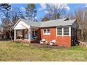 Red brick ranch house with a large covered porch and a side yard at 8300 Mount Holly Rd, Charlotte, NC 28214