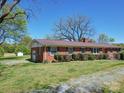 Brick ranch house with attached garage and manicured lawn at 112 W Highway 218 Rd, Monroe, NC 28110