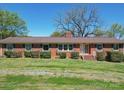 Brick ranch house featuring a classic design and landscaping at 112 W Highway 218 Rd, Monroe, NC 28110