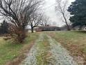Ranch house with gravel driveway and expansive yard at 112 W Highway 218 Rd, Monroe, NC 28110