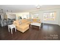 Spacious living room with L-shaped sectional sofa, hardwood floors, and large windows at 317 Gardner Point Dr, Stony Point, NC 28678