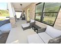 Inviting front porch with brick columns and comfortable wicker furniture at 317 Gardner Point Dr, Stony Point, NC 28678