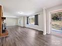 Bright living room with bay window, gray vinyl flooring, and access to backyard at 111 Bobby Lee Ln # 18, Mooresville, NC 28115