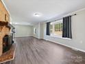 Spacious living room with fireplace, large windows, and vinyl flooring at 111 Bobby Lee Ln # 18, Mooresville, NC 28115