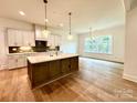 Modern kitchen boasts an island, hardwood floors, and ample cabinet space at 3860 Nc Hwy 200 Hwy, Concord, NC 28025