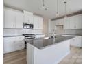 Modern kitchen with white cabinets, gray countertops, and an island at 8915 Nettleton Ave, Charlotte, NC 28215