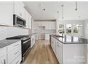 Modern kitchen with white cabinets, gray countertops, and an island at 8915 Nettleton Ave, Charlotte, NC 28215