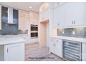 White kitchen with double ovens, wine cooler, and blue hex tile backsplash at 106 Windbluff Ct # 163, Statesville, NC 28677