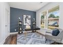 Stylish home office with a dark desk, blue accent wall, and modern shelving at 108 1St St, Huntersville, NC 28078