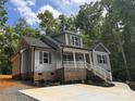 Gray house with brick accents, a front porch, and a landscaped yard at 292 Manchester Rd, Mount Gilead, NC 27306