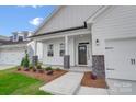 Charming front porch with stone pillars and a dark front door at 109 S Dunlavin Way # 62, Mooresville, NC 28115