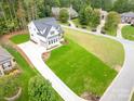 Aerial view of a white farmhouse with a large green lawn and paved driveway at 7362 Hemlock Ct, Denver, NC 28037