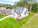 Aerial view of a white farmhouse with a gray roof and green lawn at 7362 Hemlock Ct, Denver, NC 28037