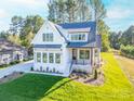 Two-story white farmhouse with gray roof, landscaping, and a paved driveway at 7362 Hemlock Ct, Denver, NC 28037