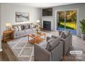 Virtually staged living room with fireplace and patio access at 3021 Heathstead Pl # D, Charlotte, NC 28210