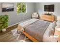 Bright bedroom with wood-look floors, featuring a comfortable bed and stylish furniture at 3021 Heathstead Pl # D, Charlotte, NC 28210
