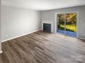 Living room with fireplace, patio access, and wood-look floors at 3021 Heathstead Pl # D, Charlotte, NC 28210