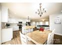 Open concept kitchen with island, white cabinets, and dining area at 539 N C Ave, Maiden, NC 28650