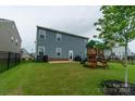Fenced backyard with a playset and patio area at 424 Wharton St, Monroe, NC 28110