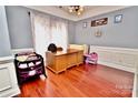 Home office with hardwood floors, desk, and crib at 9841 Baxter Caldwell Dr, Charlotte, NC 28213