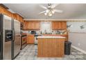 Kitchen with island, stainless steel appliances, and wood cabinets at 1820 Oakdale Green Dr, Charlotte, NC 28216