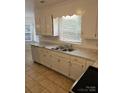 Kitchen with white cabinets, double sink, and tile floor at 2819 Royal Ridge Ln, Charlotte, NC 28212