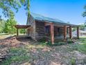 Rustic log cabin with a covered porch and brick pillars at 10910 Archer Rd, Davidson, NC 28036