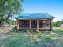 Rustic wooden home with a green metal roof and a large front porch at 10910 Archer Rd, Davidson, NC 28036