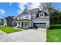 Two-story house with gray siding, a covered porch, and a two-car garage at 2016 Cedar Falls Dr # 7, Waxhaw, NC 28173