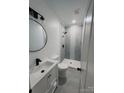 Modern bathroom with gray tile shower and round mirror at 115 Palmer St, Shelby, NC 28150