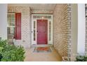 Red front door with brick exterior and porch at 8714 Brideswell Ln, Charlotte, NC 28278