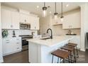 Modern kitchen with white cabinets, quartz countertops, and island at 5919 Wetlands Aly, Charlotte, NC 28215