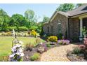 Landscaped yard with brick walkway, lush greenery, and flowers at 4642 King Crowder Dr, Gastonia, NC 28052