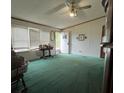 Mobile home living room with green carpet and ceiling fan at 7141 Lingerfelt Rd, Vale, NC 28168