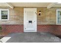 White front door with sidelights and brick accents at 810 Hampton St, Shelby, NC 28152