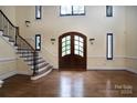 Two-story entryway with hardwood floors, a grand staircase, and double doors at 2708 Chilton Pl, Charlotte, NC 28207
