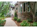 Stone and stucco house exterior with a curved walkway and landscaping at 2708 Chilton Pl, Charlotte, NC 28207
