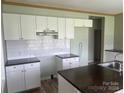 White kitchen cabinets, dark countertops, and an island at 200 Olin Loop, Olin, NC 28660