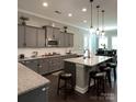 Spacious kitchen with gray cabinets, granite countertops, and island at 2044 Sweet William Dr, Harrisburg, NC 28075