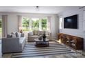 Relaxing living room with large windows and striped rug at 1008 Briar Well St, Mint Hill, NC 28227